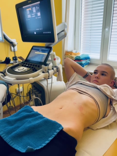 Teenage girl Taylor is lying on an examination table with her shirt pulled up after having an ultrasound scan done.